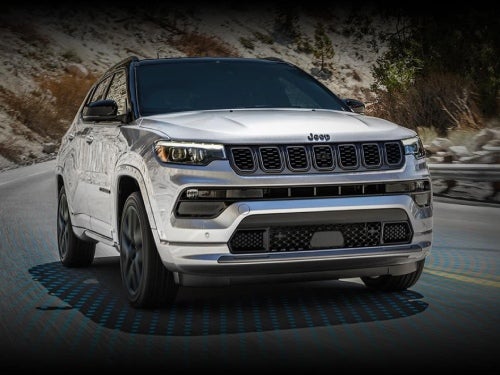 2024 Jeep Compass driving on road with model view of active driving assist system sensors on road
