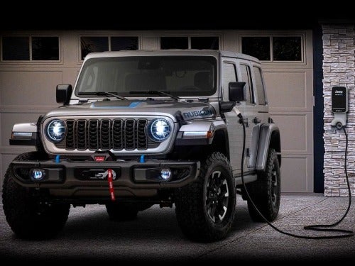 2024 Jeep Wrangler 4xe charging outside a home